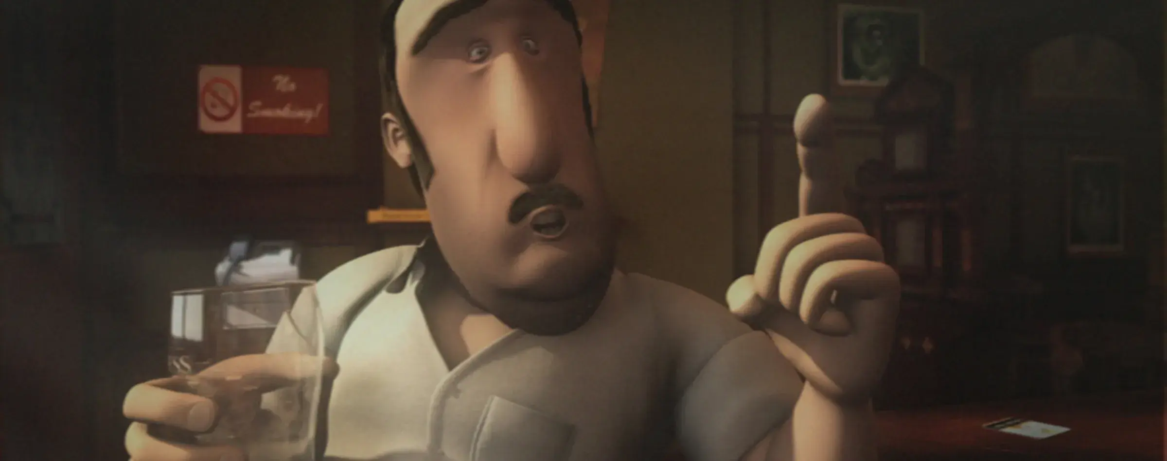 Bartender Denny holding a pint glass and gesturing with his hand.