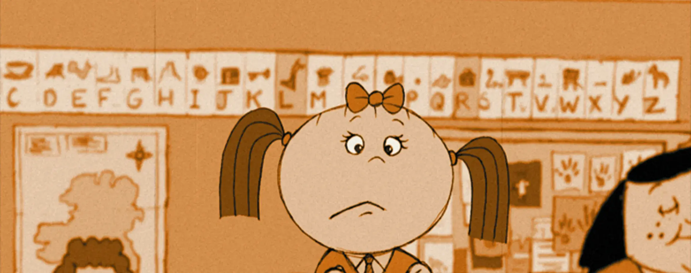 A classroom scene with a young student sitting at a desk looking up at a microphone hanging from the ceiling. Other students are visible in the background.