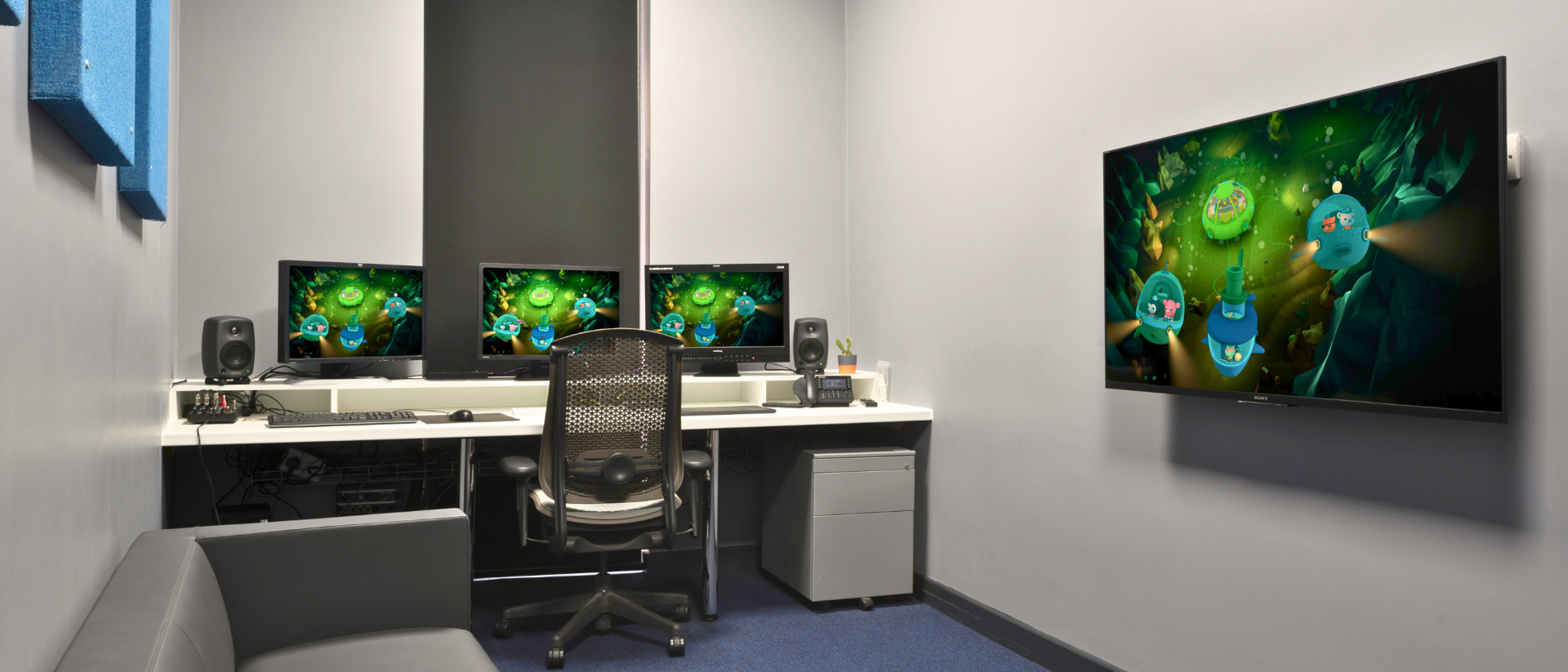 Workspace with multiple monitors displaying colorful graphics.