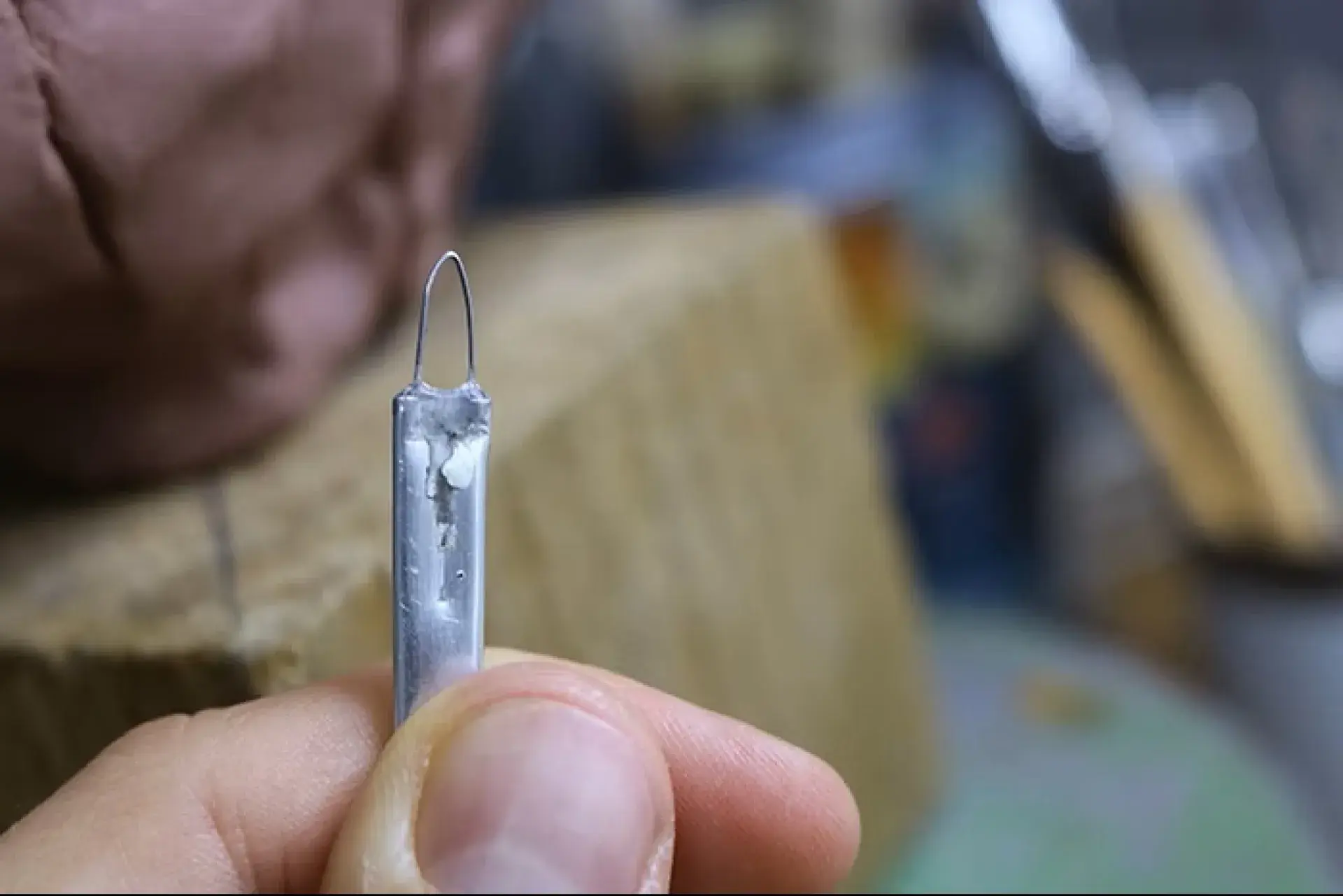 Wire loop sculpting tool held close-up for clay detailing.