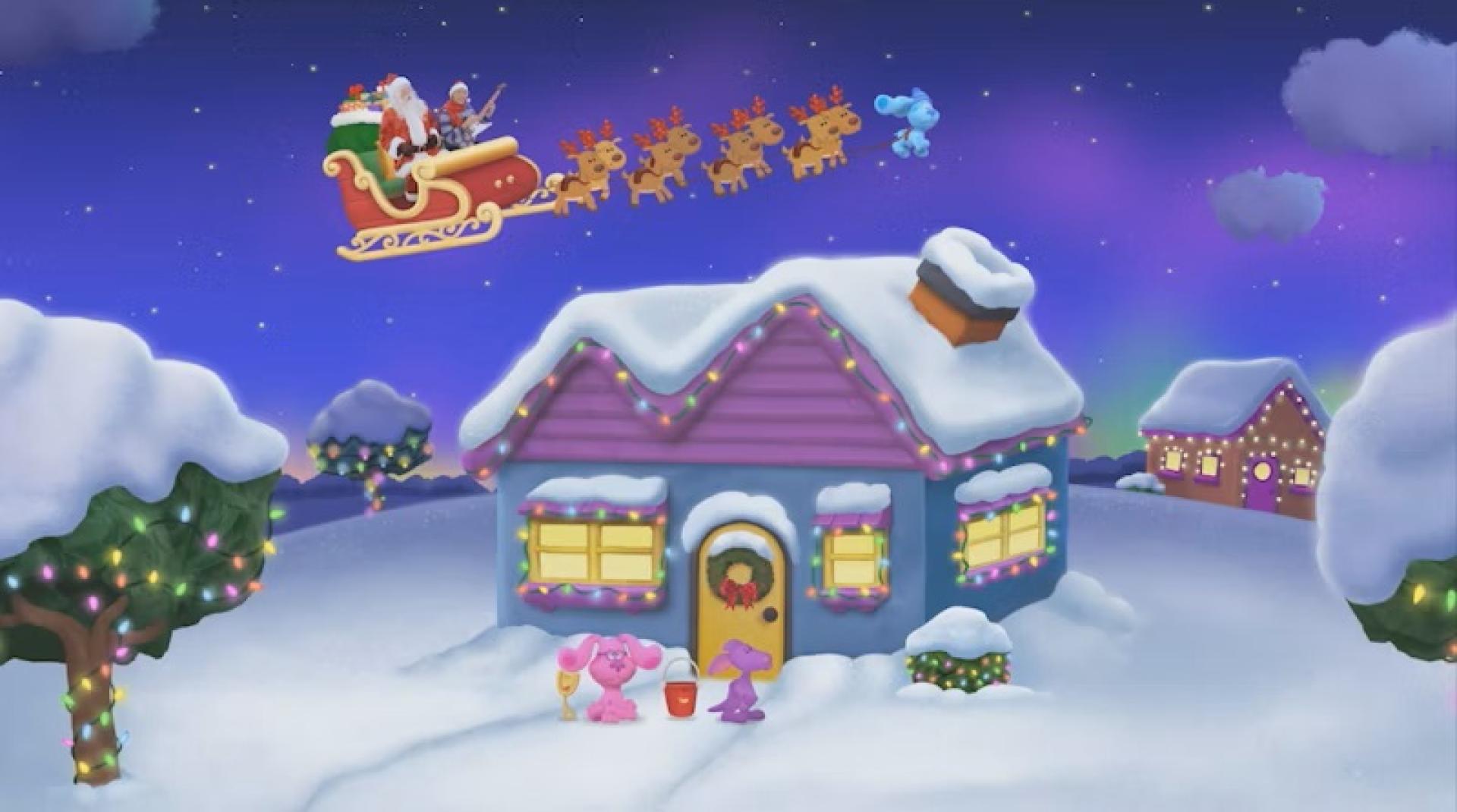 Santa’s sleigh with reindeer flying over a snow-covered house decorated with Christmas lights.