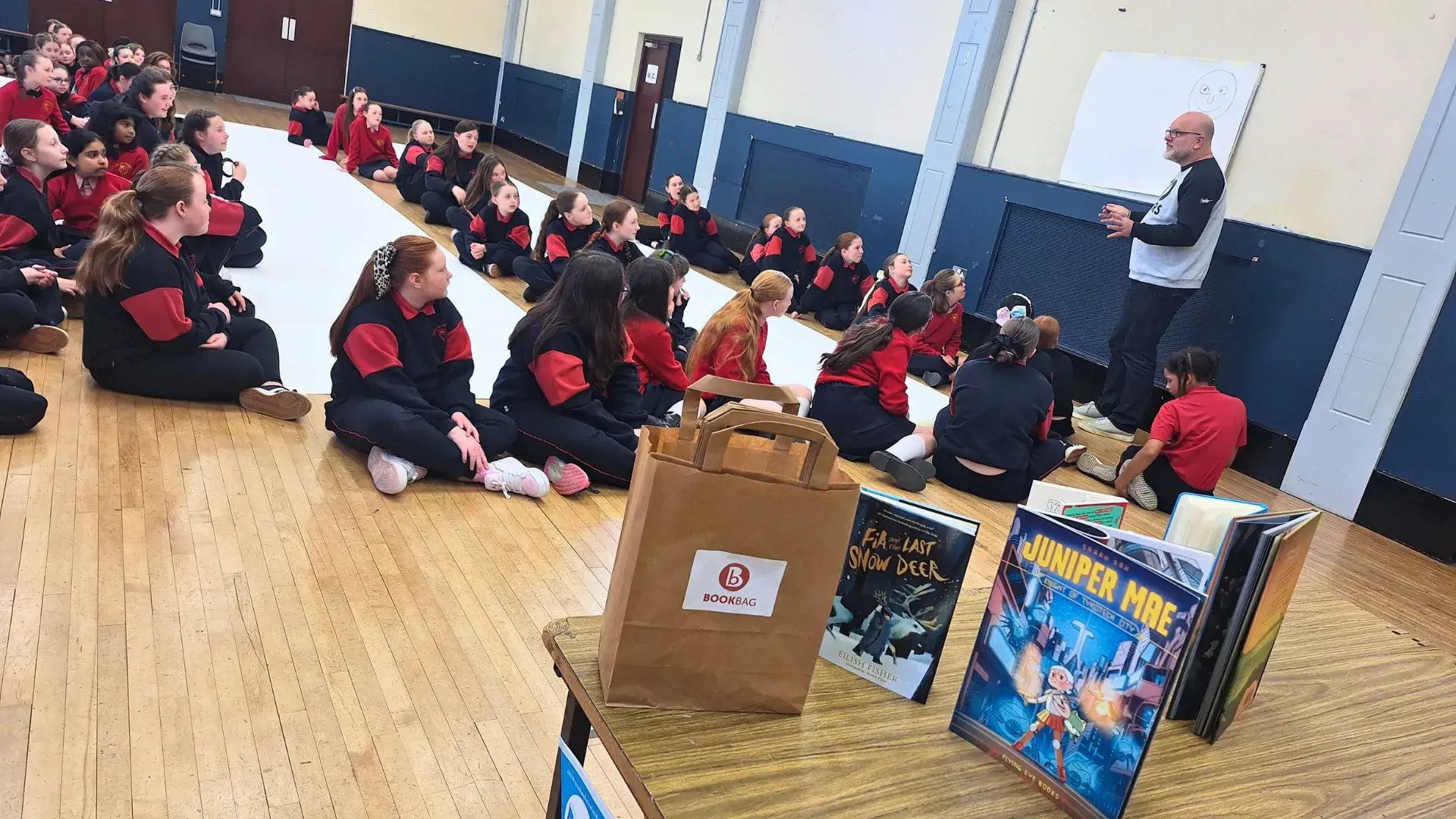Children drawing a large monster doodle in their school gym