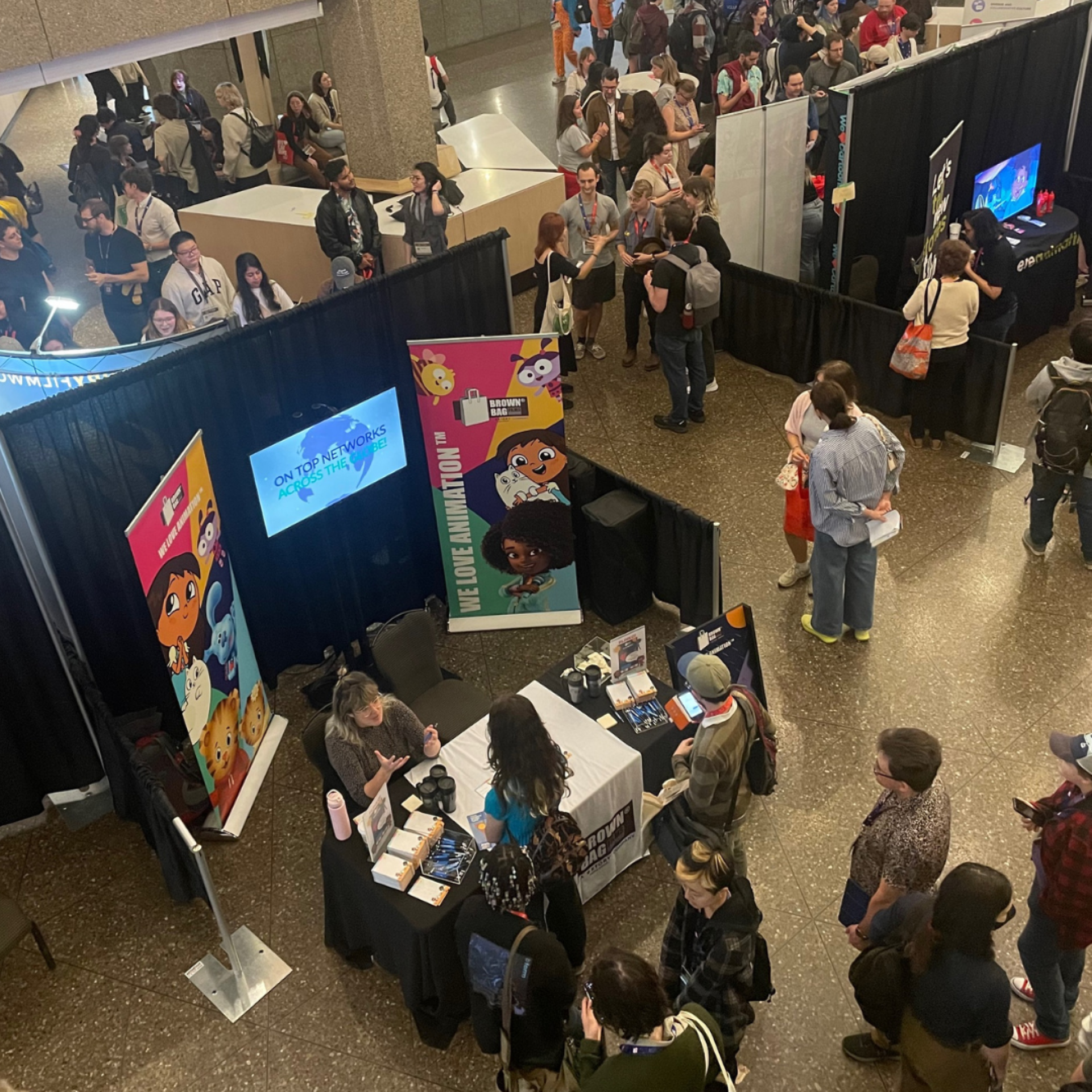 A top down photo of people walking around the booths at the Ottawa International Animation Festival 2023