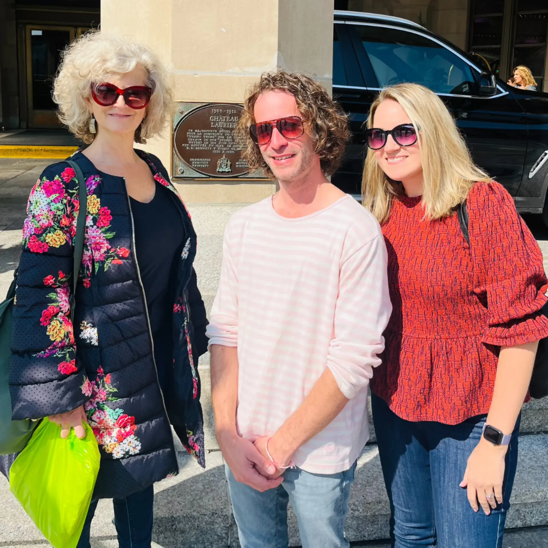 Three people standing together wearing sunglasses