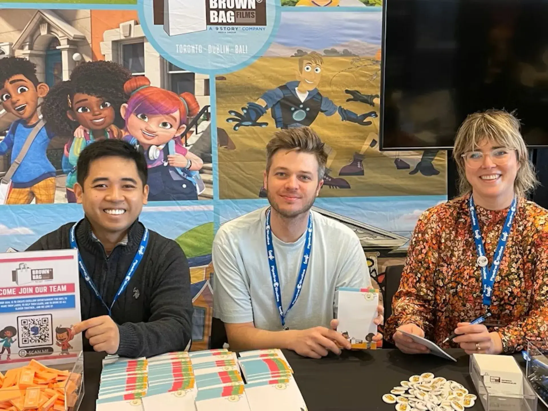 Brown Bag Films booth with branded backdrop, promotional materials, and team members seated at a table.