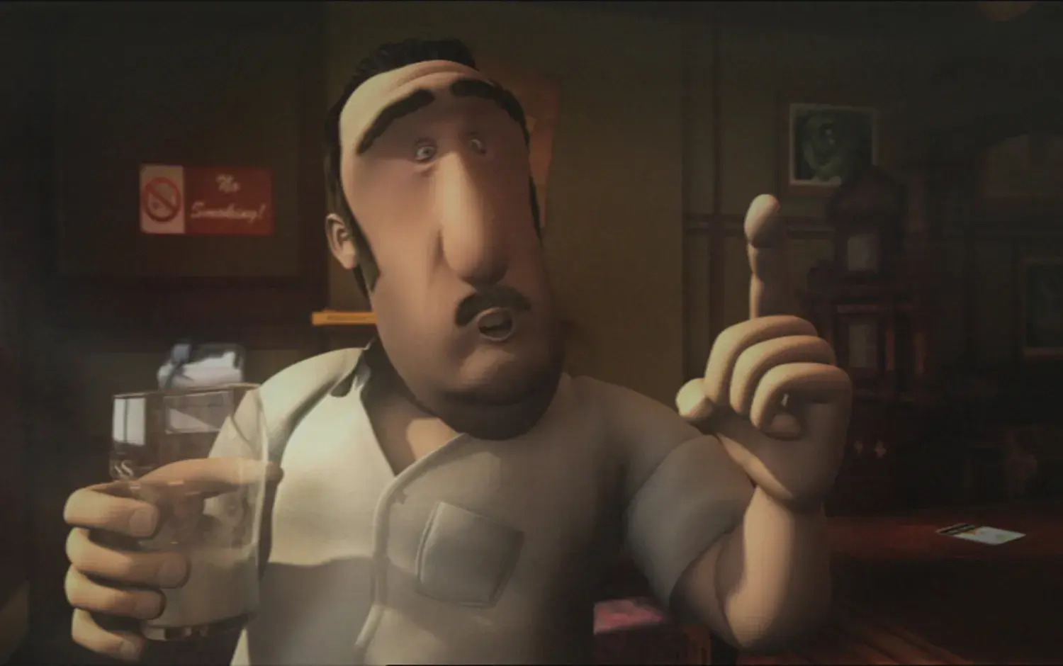 Bartender Denny holding a pint glass and gesturing with his hand.