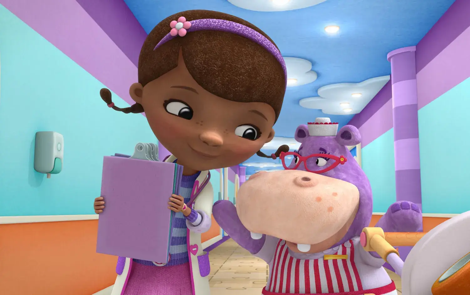 Doc McStuffins holding a clip board walking down the Toy Hospital hallway with Hallie