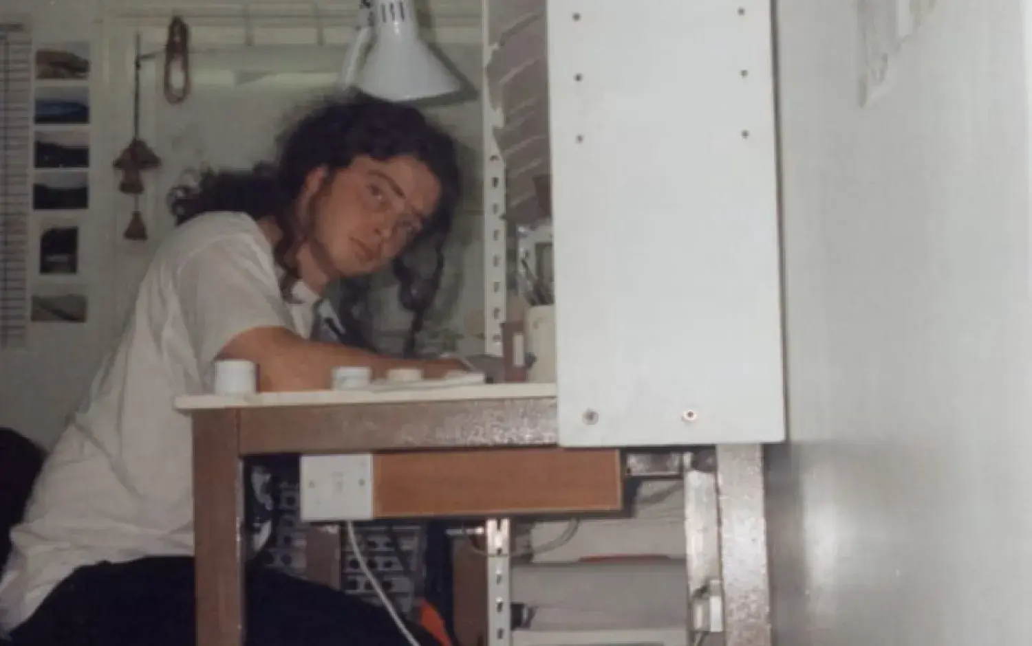 Darragh O'Connell working in a the studio in 1994, in a cluttered room filled with paper and paint.