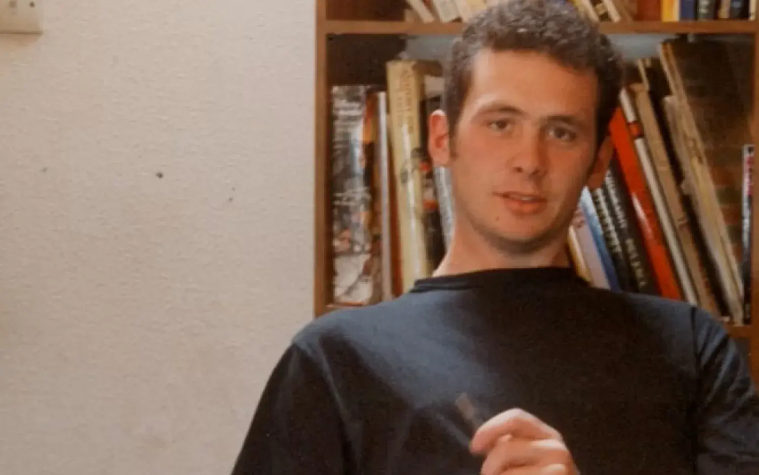 Cathal Gaffney in the studio in 1994 with bookshelves behind him.
