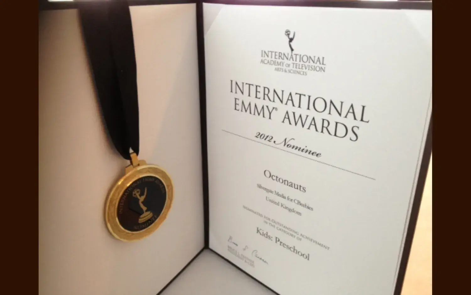 Open display case showing an International Emmy Awards certificate and medal for Octonauts.