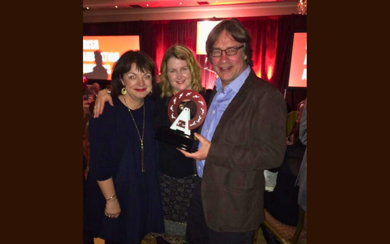 Group posing at an event, one person holding an Irish Animation award.