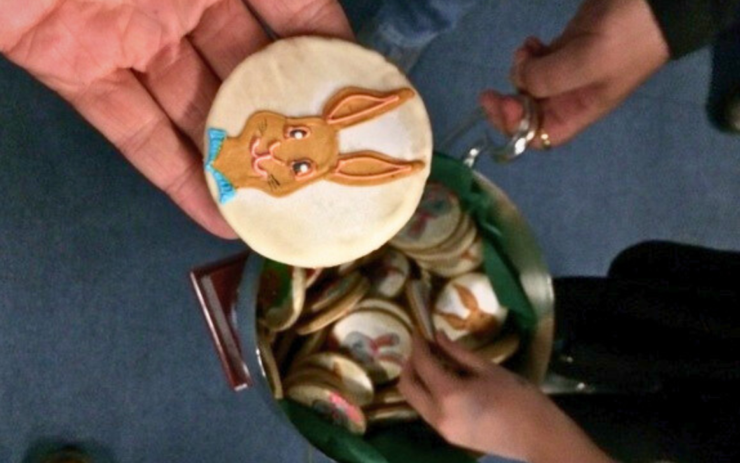 Close-up of a decorated cookie featuring a cartoon rabbit face with a blue bow tie.