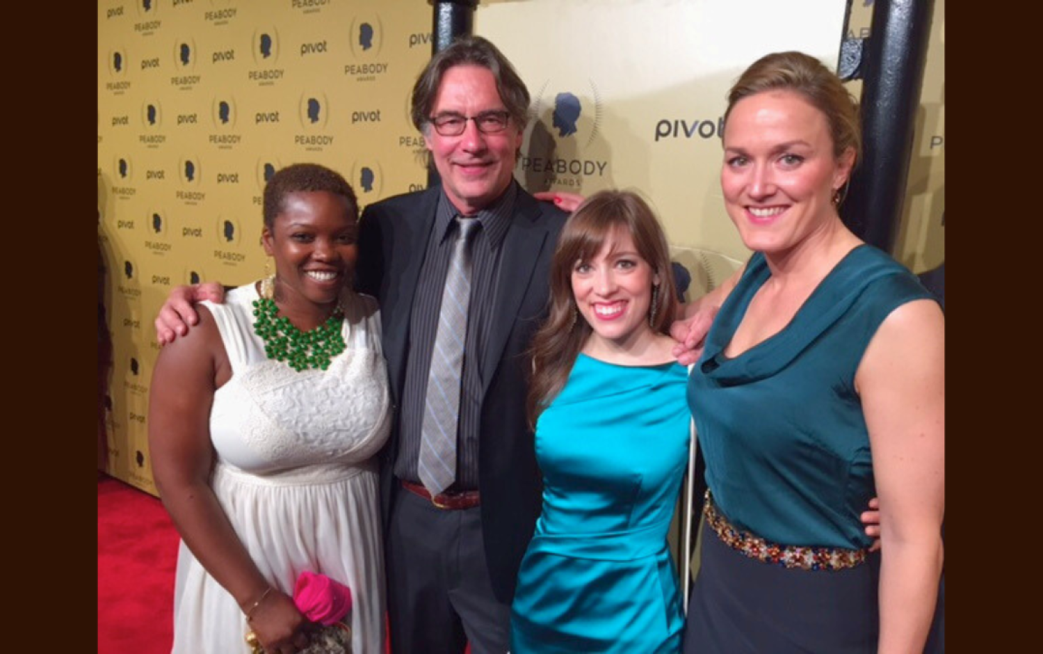 Four people posing together on Peabody Awards red carpet.