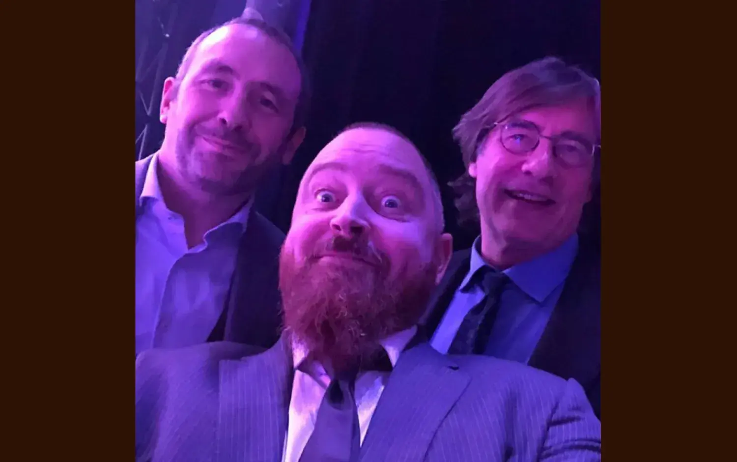 Close-up selfie taken in a dimly lit event space with purple lighting.