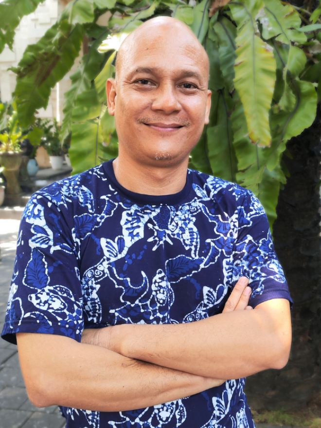 A photo of Faseh Hulisan standing outside, a tree in the background.