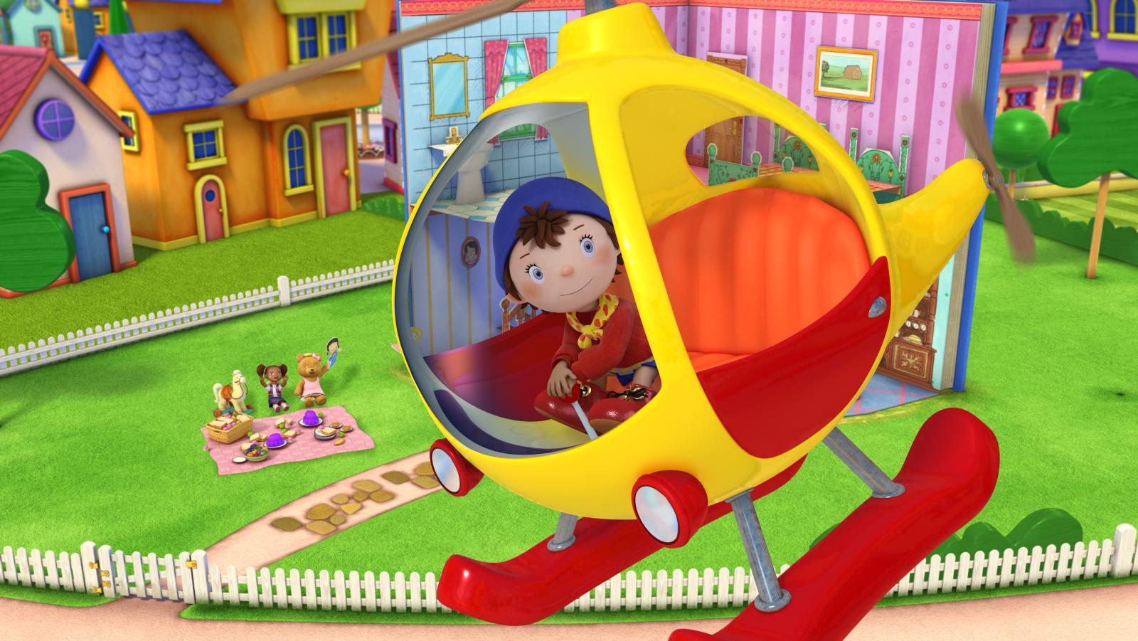 Noddy in a yellow and red helicopter soaring above Toyland