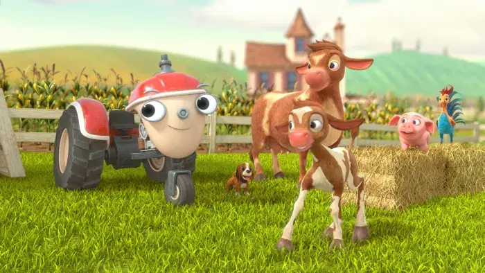 Otis next to a cow and her calf, with the farm in the background