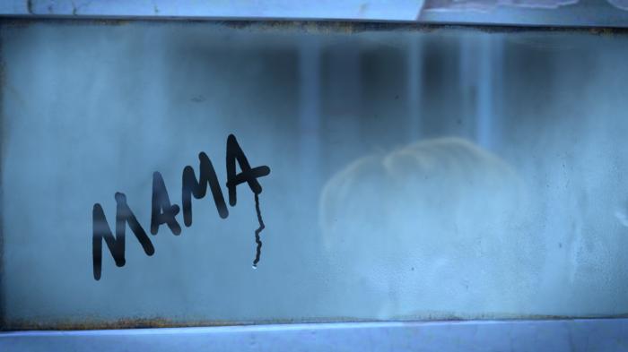 A still from the short film Anya featuring a young orphan girl on a train with the word mama scrawled on the steamed up window