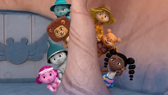 Dee and her friends peeking out from behind a rock pillar