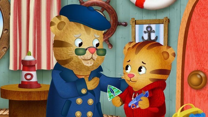 Daniel Tiger's Neighborhood: Character with glasses shows something to another character.