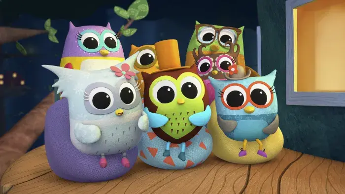 a group of colourful owls sitting on bean bags facing forward