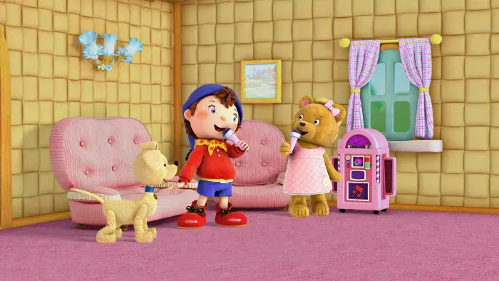 Noddy and a bear toy character in a pink check dress, singing holding pink microphones