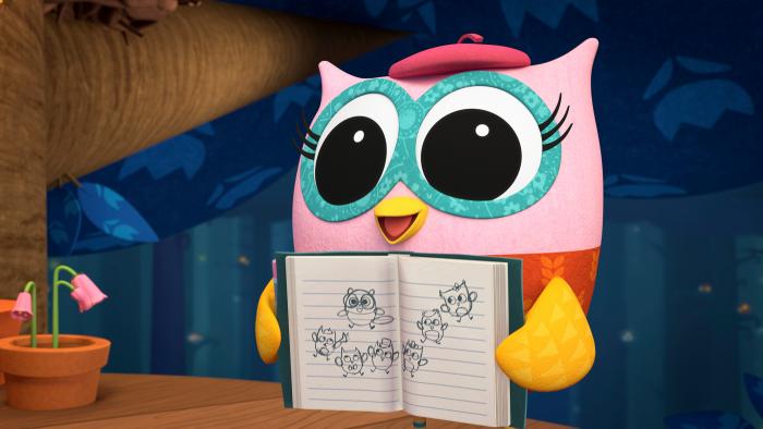 Pink owl holding a notebook with sketches.
